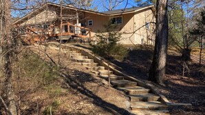 A stone staircase leading to a house surrounded by trees.