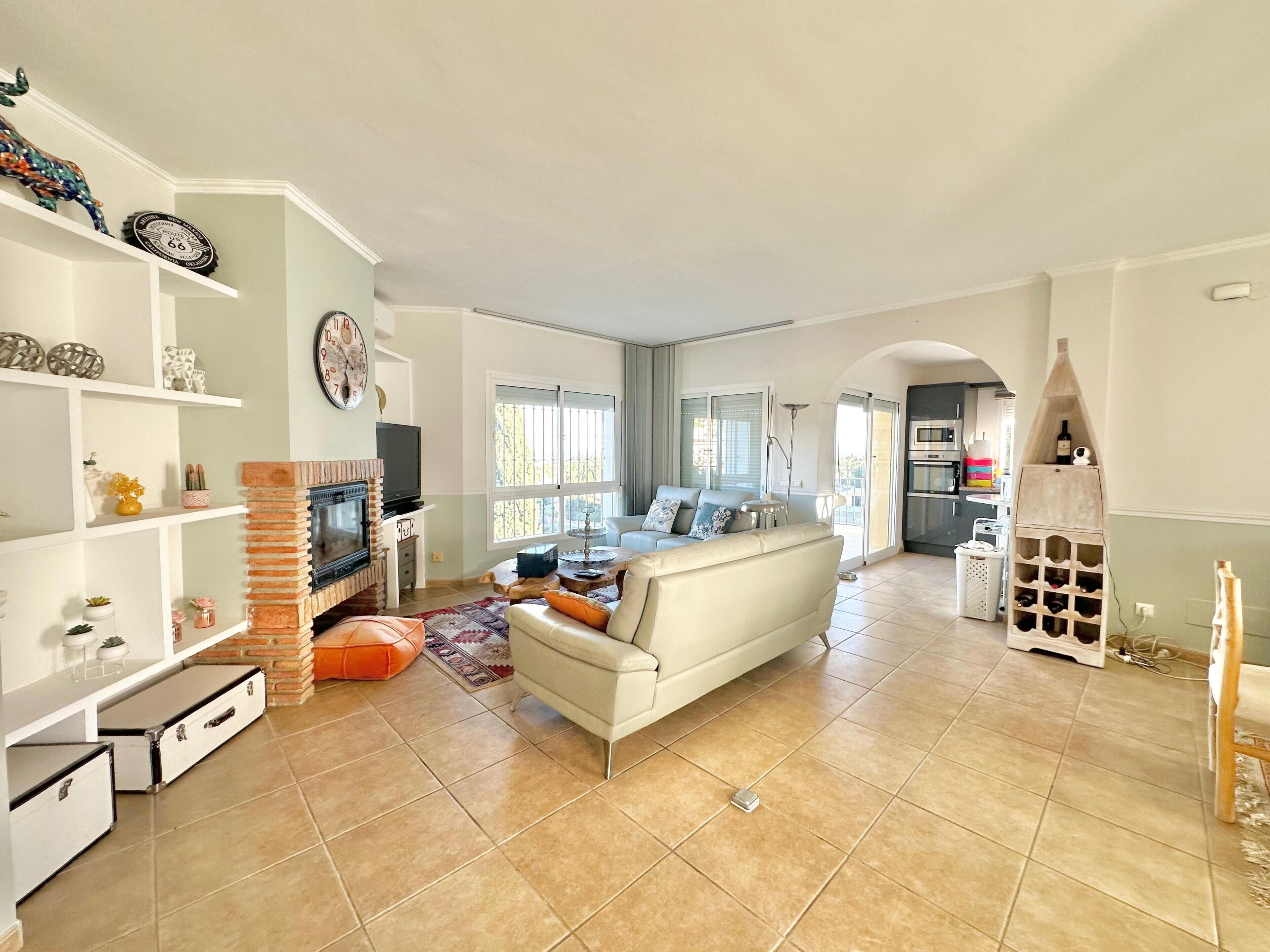 A spacious living room with a fireplace, a sofa, and a television.