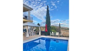 Ein Swimmingpool mit blauem Himmel und einem hohen Baum im Hintergrund.