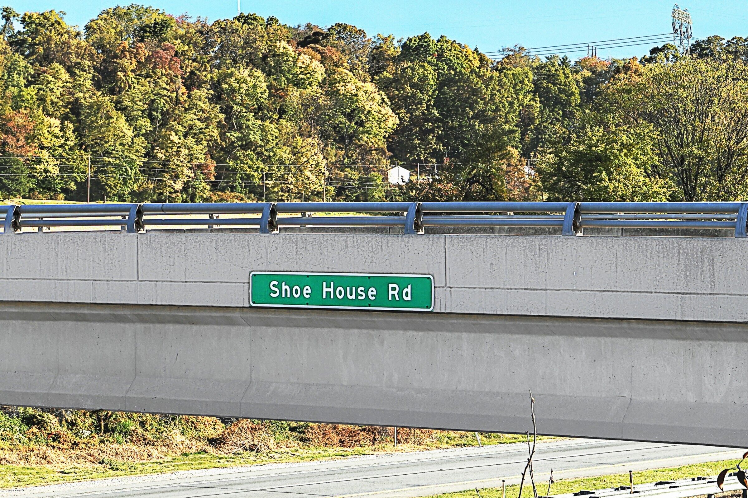 A concrete bridge with a street sign reading "Shoe House Rd."