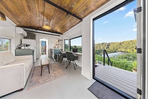 Un intérieur moderne comprenant une cuisine, un coin repas et un balcon offrant une vue panoramique.
