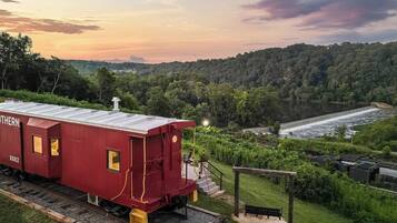 A red train car labeled 'SOUTHERN' with a platform and a scenic view of a river and forested hills.