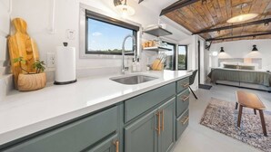 Una cocina moderna con un ventanal grande, un lavaplatos empotrado y una tabla de cortar de madera.