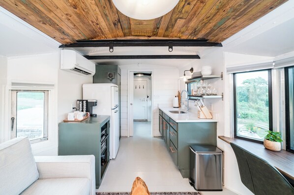 Una cocina moderna con una isla central, electrodomésticos integrados y vistas al exterior.