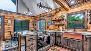 A modern kitchen with wooden accents, a built-in stove, and a large island. - Rustic Hideaway Sleeps 4 HOT TUB (De Soto)