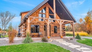 A log cabin with a large porch, outdoor seating, and a stone pathway leading to the entrance. - Rustic Hideaway Sleeps 4 HOT TUB (De Soto)