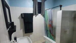 A bathroom with a sink, a shower, and a toilet. - Beach-side one bedroom (Kwale County)