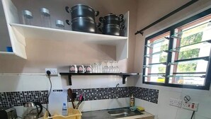 A compact kitchen with a gas stove, a sink, and a countertop with various kitchen items. - Beach-side one bedroom (Kwale County)