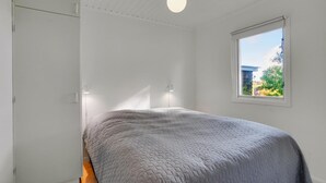 Quarto com cama, janela e luminária no teto.