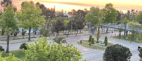 Eine Stadtlandschaft bei Sonnenuntergang, mit Straßen und Grünflächen.