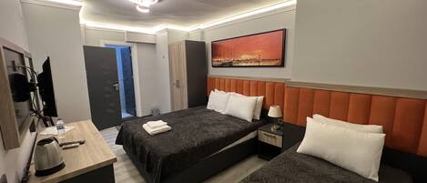 A hotel room with two beds, a desk, a TV, and a painting on the wall.