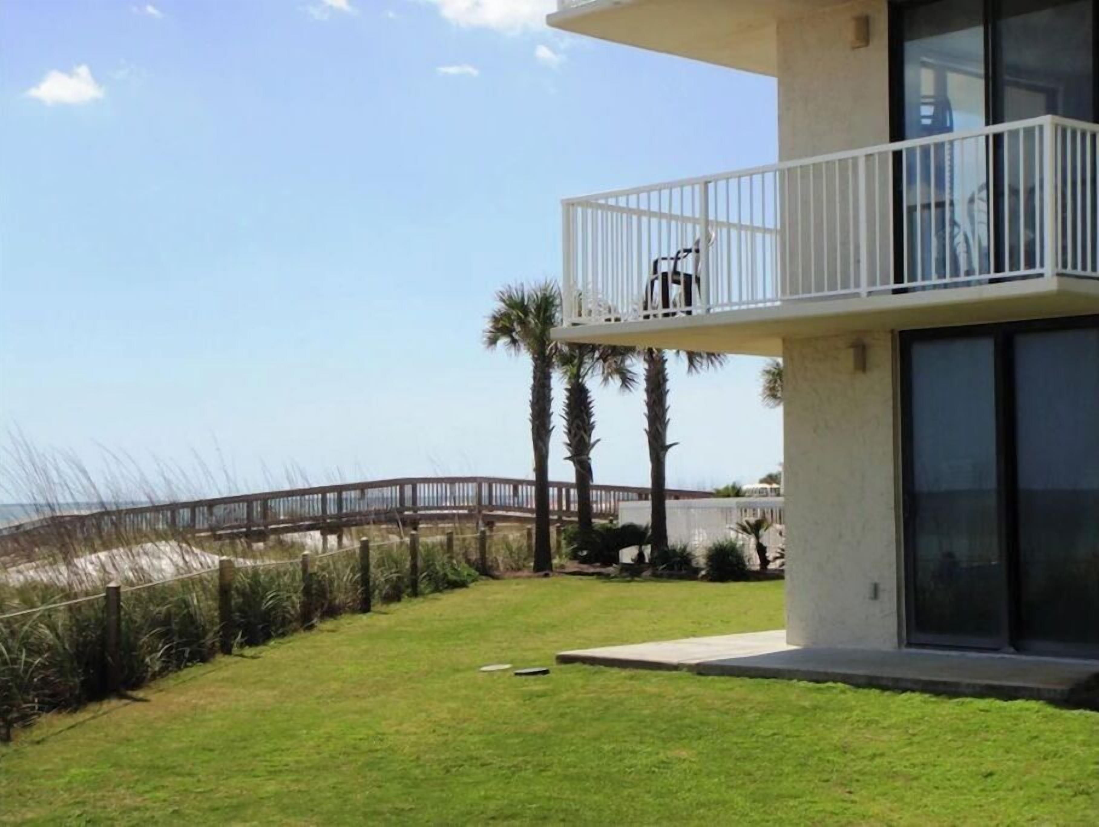 Een modern gebouw met balkon, met uitzicht op een strand.