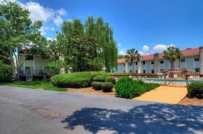 Hotel com piscina, galeria coberta e jardins bem cuidados.
