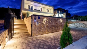 A modern two-story house with a stone facade, a staircase leading to the entrance, and a small tree in the foreground. - Awesome home in Drace with sauna (Drace)