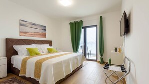 A bedroom with a bed, a nightstand, a TV, and a view of the outdoors. - Awesome home in Drace with sauna (Drace)