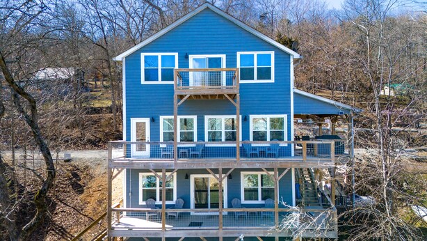A two-story house with a balcony and a covered porch.