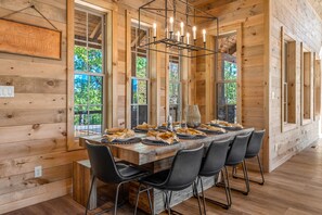 Enjoy a formal meal in this cozy cabin's dining area, complete with a long wooden table and comfortable seating for all.