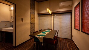 A modern dining area with a wooden table, chairs, and a decorative table runner. - TSUDOYA Sannou (Osaka)