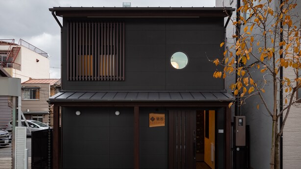 A modern building with a dark facade, a circular window, and a sign reading "SUBOYAMA". - TSUDOYA Sannou (Osaka)