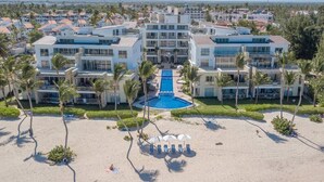 Un complejo turístico con piscina central, varias edificaciones y zona de playa.