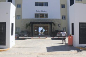 Un edificio con un letrero que dice 'Costa Atlántica' y una entrada protegida por un guardia de seguridad.