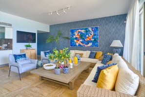 A modern living room with a sofa, coffee table, and decorative plants.