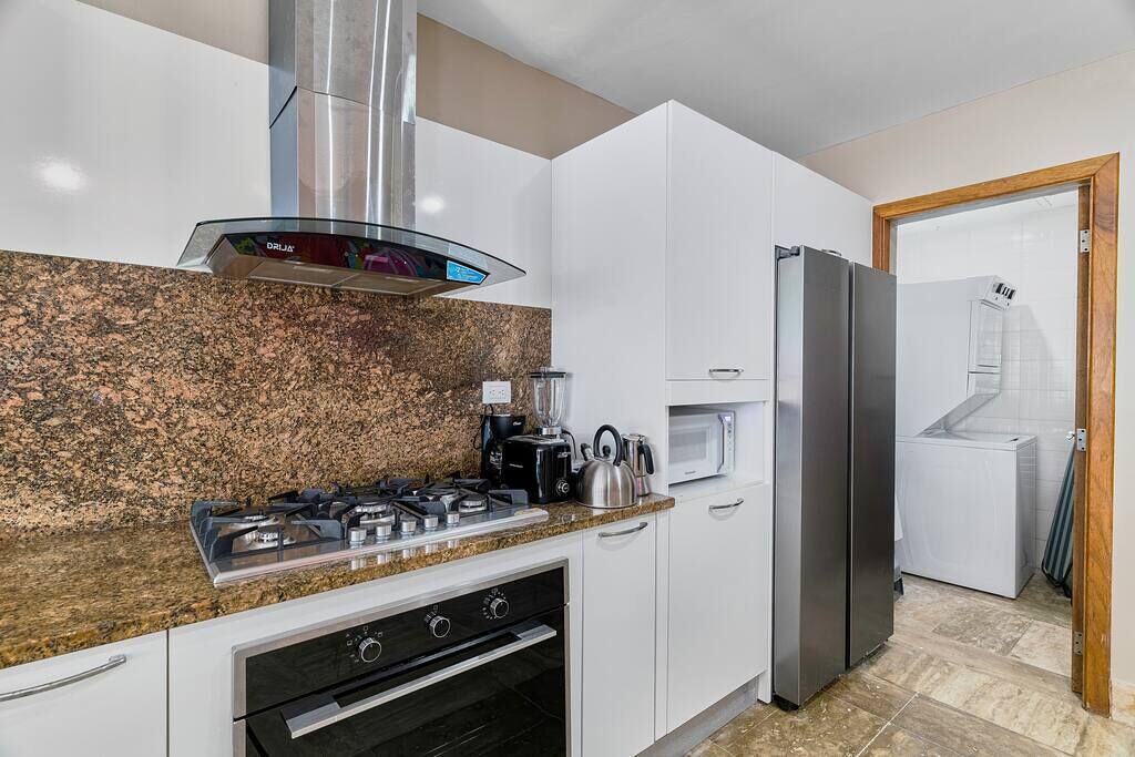 Una cocina moderna con estufa a gas, horno, microondas y refrigerador de acero inoxidable.