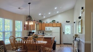 A spacious kitchen with wooden cabinets, a central island, and a dining area with a wooden table and chairs. - Get Ready For Summer At Anglers Inn-1 mile from Pkwy (Pigeon Forge)