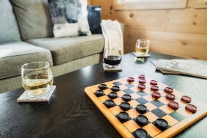 Un juego de mesa de madera sobre una mesa con una copa de vino blanco y una copa de vino tinto.