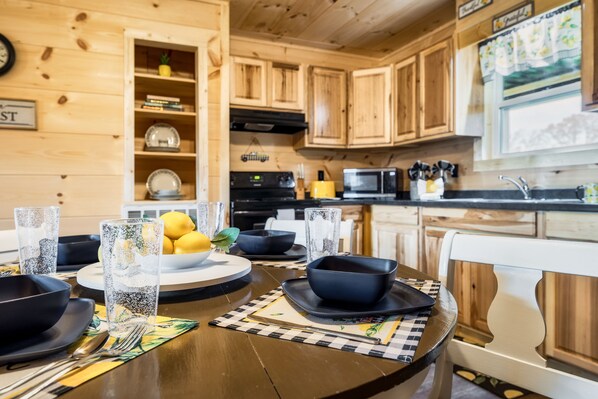 A wooden kitchen with a dining table set for two, including bowls, plates, and glasses. - Heavenly Daze!!! Mountain Getaway!!!! (Cosby)