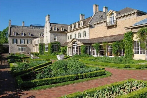 Stately building with a classical facade, featuring a central entrance and well-manicured grounds.