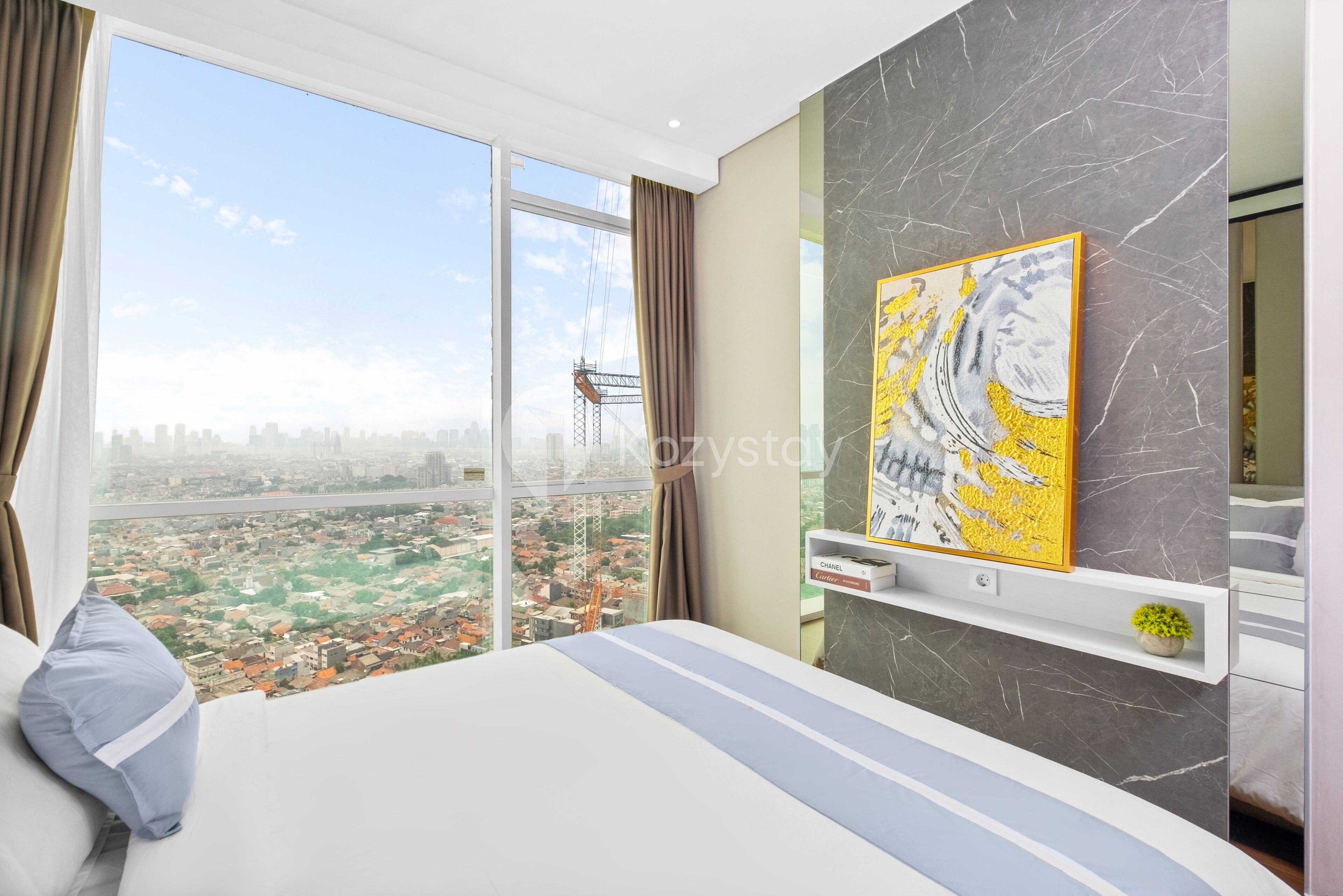 Ein modernes Schlafzimmer mit einem großen Bett, Blick auf die Stadt durch ein Fenster, einer Marmorwand und einem Gemälde.