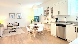 A modern apartment with a dining area, kitchen, and living space.
