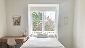 Ein Schlafzimmer mit einem Bett, einem Schreibtisch und einem Stuhl.