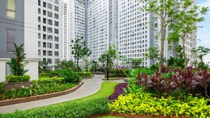 Um complexo residencial com edifícios altos, jardins bem cuidados e um caminho sinuoso.