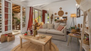 A cozy living room with a sofa, coffee table, and wicker baskets. - Villa Mahana Martinique (Les Trois-Îlets)