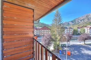 A wooden balcony with a view of a mountain and buildings. - Il Rododendro (City Center) (Bardonecchia)