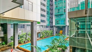 Un bâtiment moderne doté d’une piscine centrale entourée de verdure.