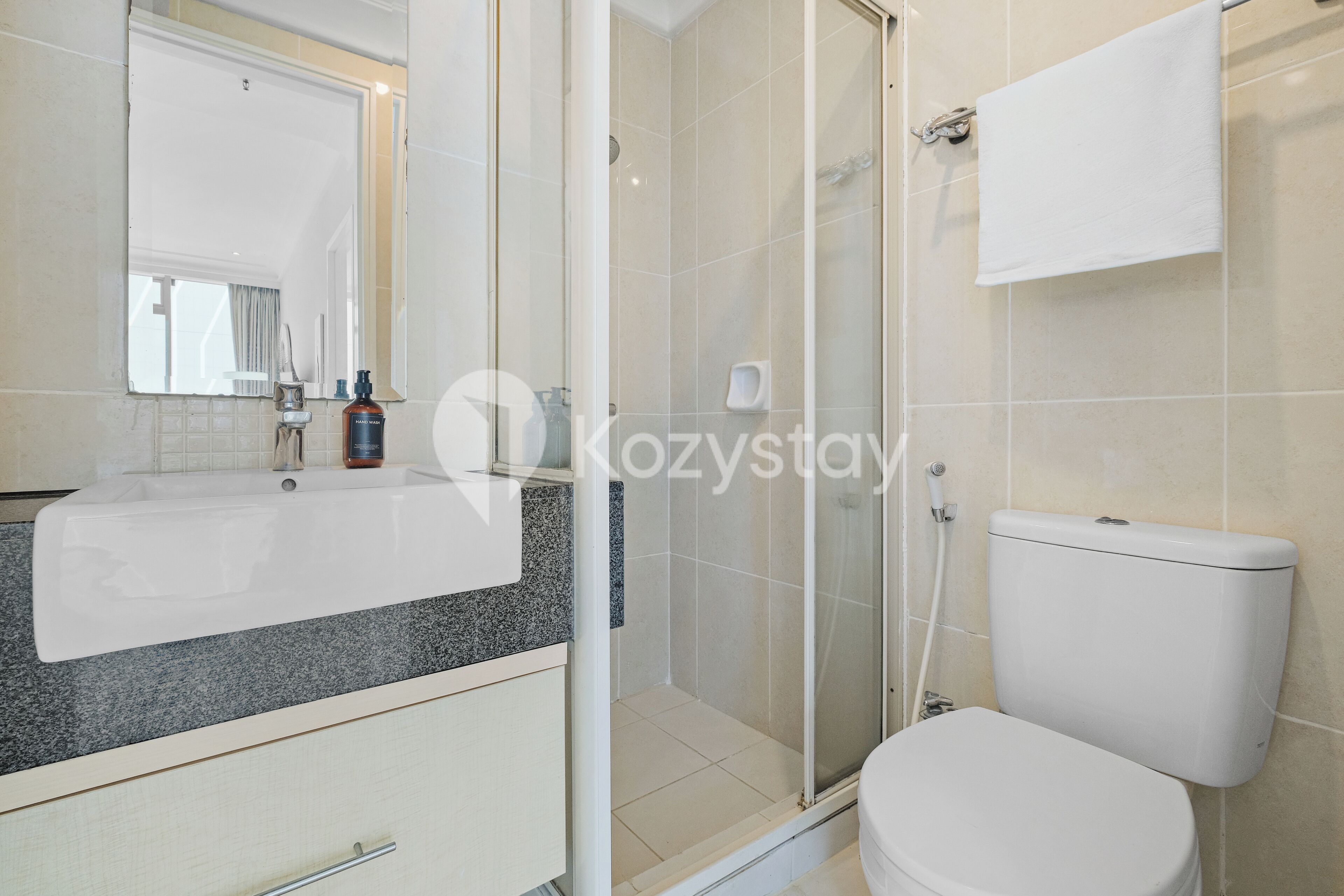 A bathroom with a sink, mirror, toilet, and shower.