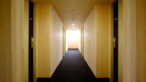 Pasillo de hotel con puertas numeradas 801 y 808, piso alfombrado y una luz en el techo.