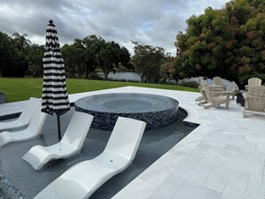 A pool area with lounge chairs, a hot tub, and outdoor furniture. - Historic lakefront guesthouse (Orlando)