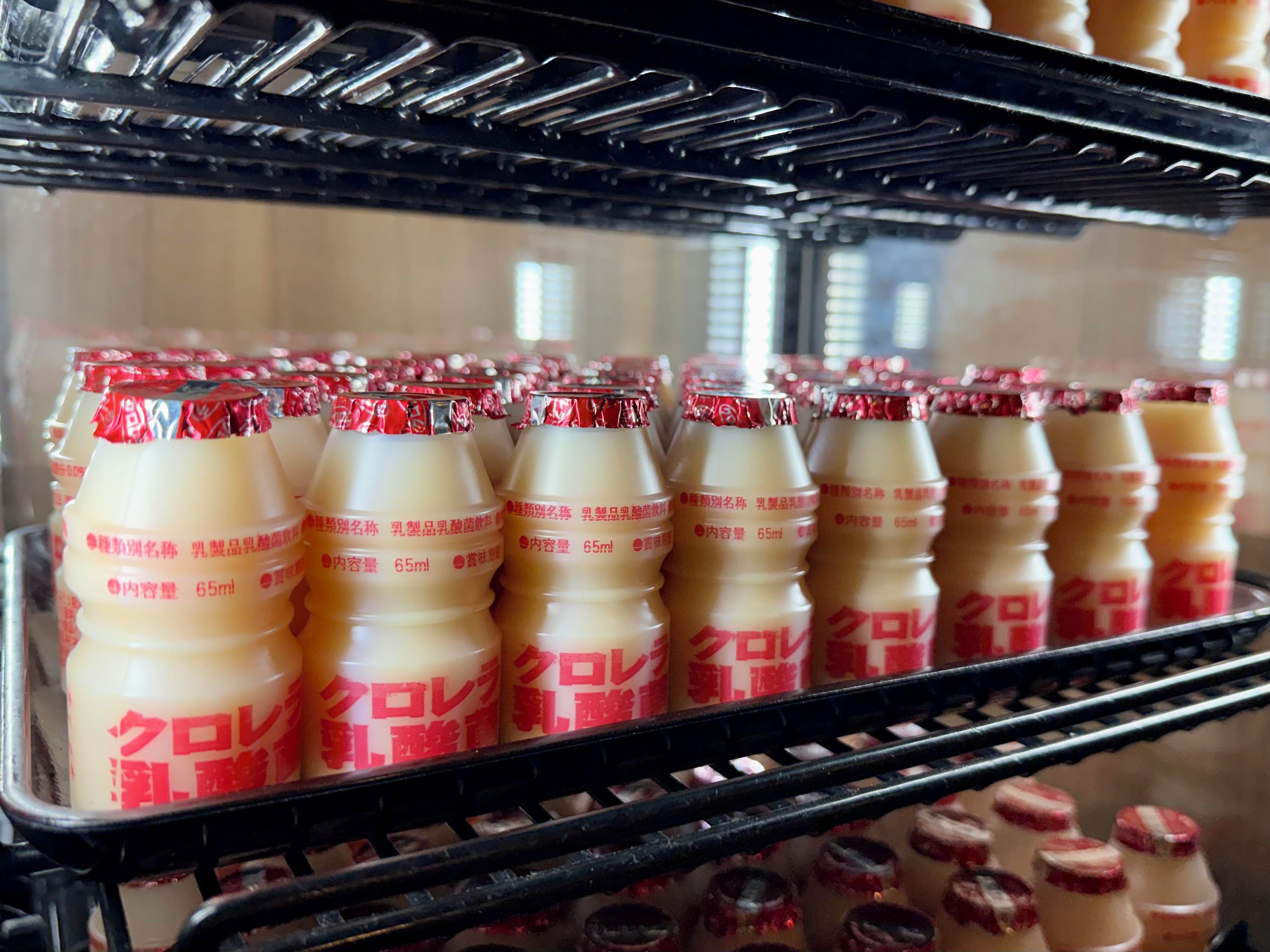 A refrigerated display case with rows of bottled beverages.
