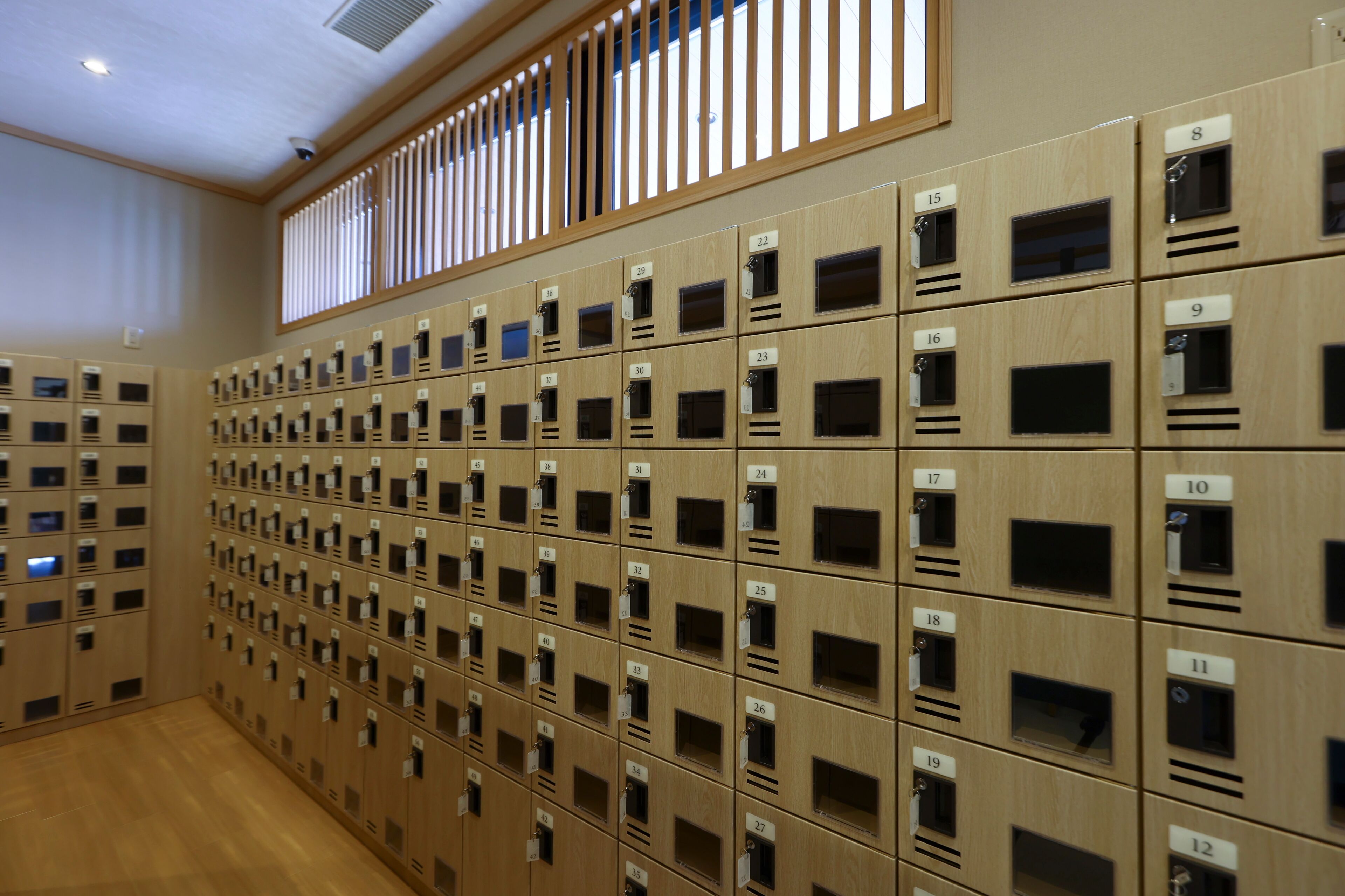 A row of wooden lockers with numbered labels, arranged in a grid pattern.