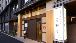 A traditional Japanese building with a wooden facade and a signboard. - aduminoyu onyado nonomatsumoto (Matsumoto)