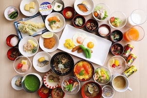 Una variedad de platos y bebidas sobre una mesa, incluyendo sushi, sashimi y un tazón de sopa.