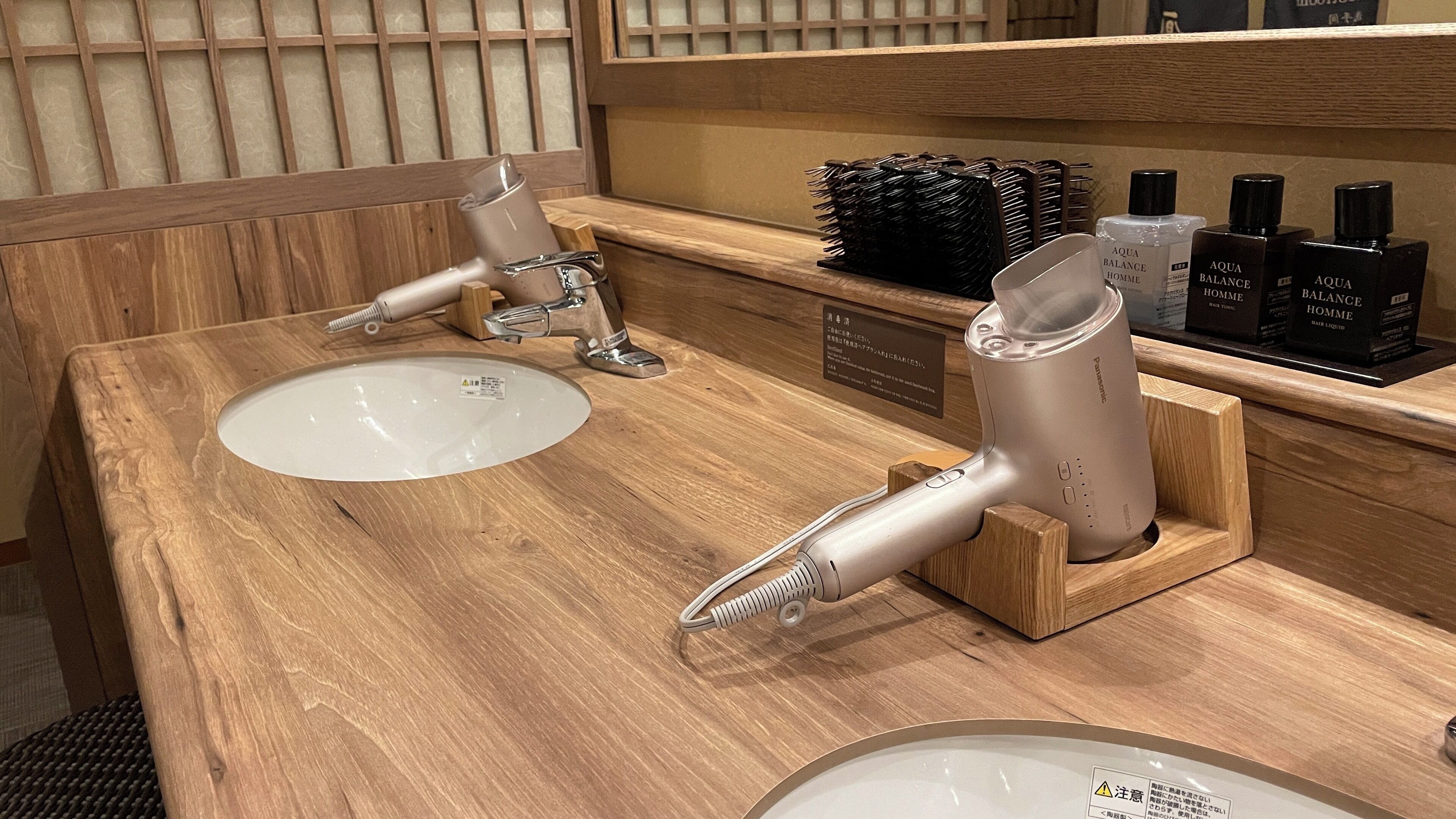 A bathroom with wooden countertops, two sinks, and a hairdryer.