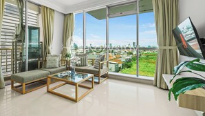 Uma sala de estar moderna com uma janela grande, um sofá, uma mesa de centro e uma TV.