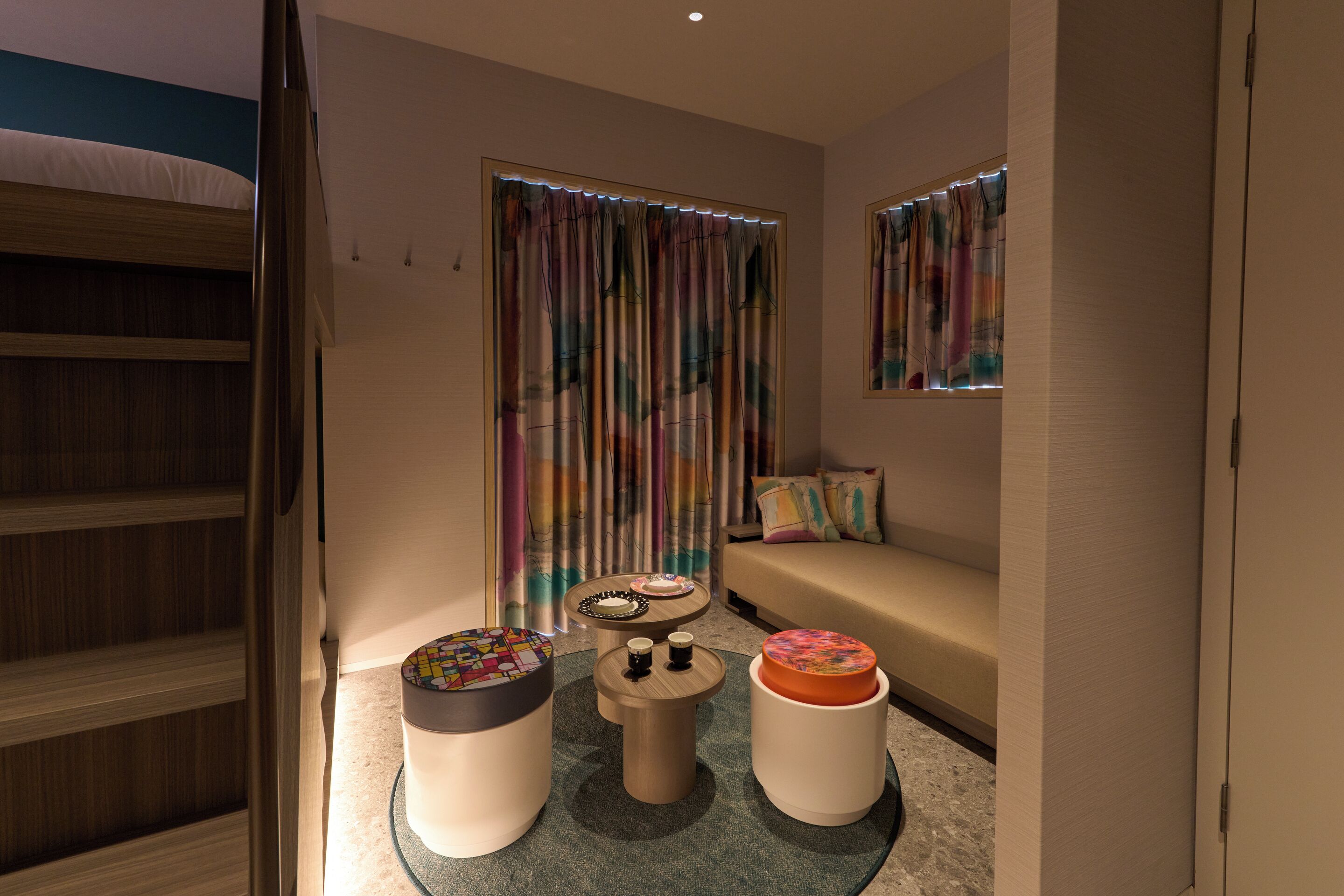 A modern room with a bunk bed, a sofa, and a coffee table with decorative items.