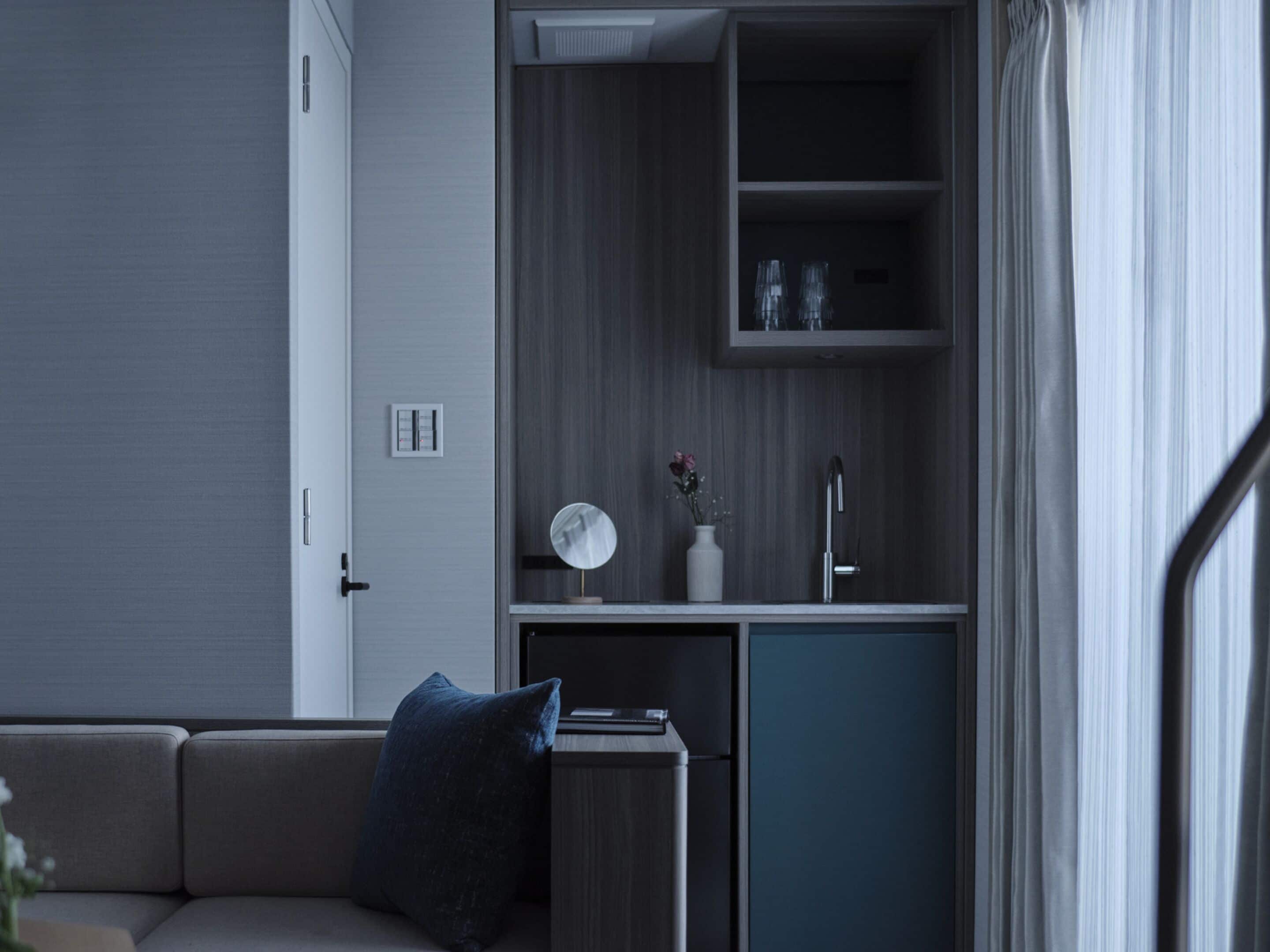 A modern kitchenette with a built-in oven, a sink, and a small countertop.