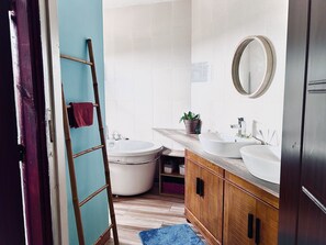 Tina con regadera, toallas, papel de baño 